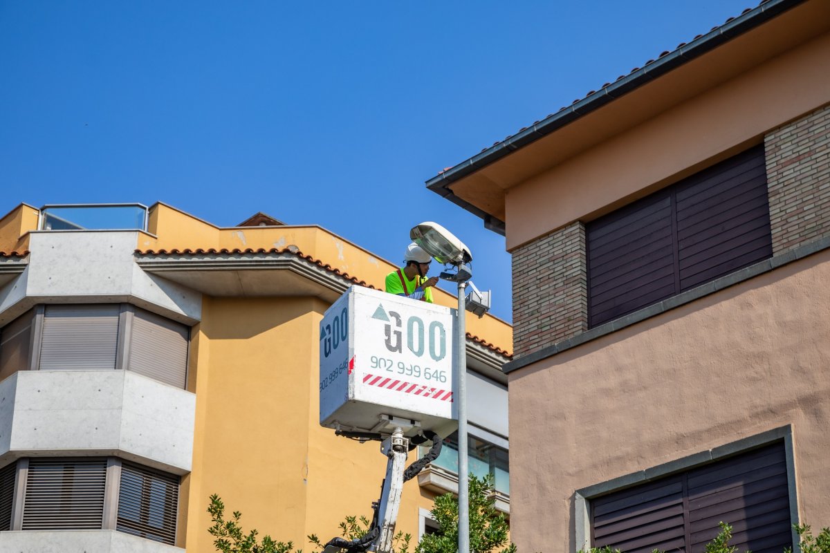 Operaris canviant una de les lluminàries del carrer de Jaume I el Conqueridor