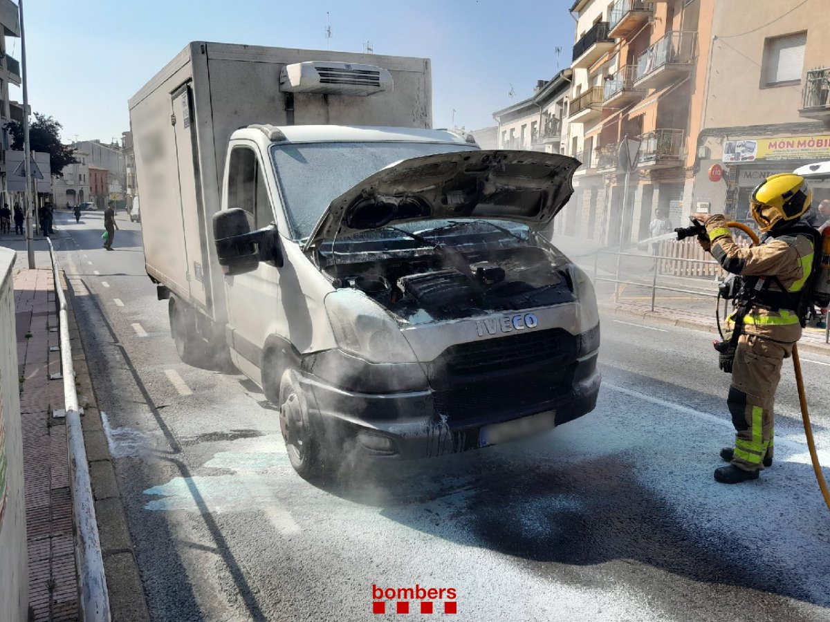 Els bombers apagant l'incendi al motor del camió