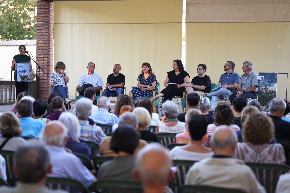 Montse Verdaguer, directora de la revista RDT, al faristol, acompanyada de bona part del consell editorial, dilluns, a Can Planoles
