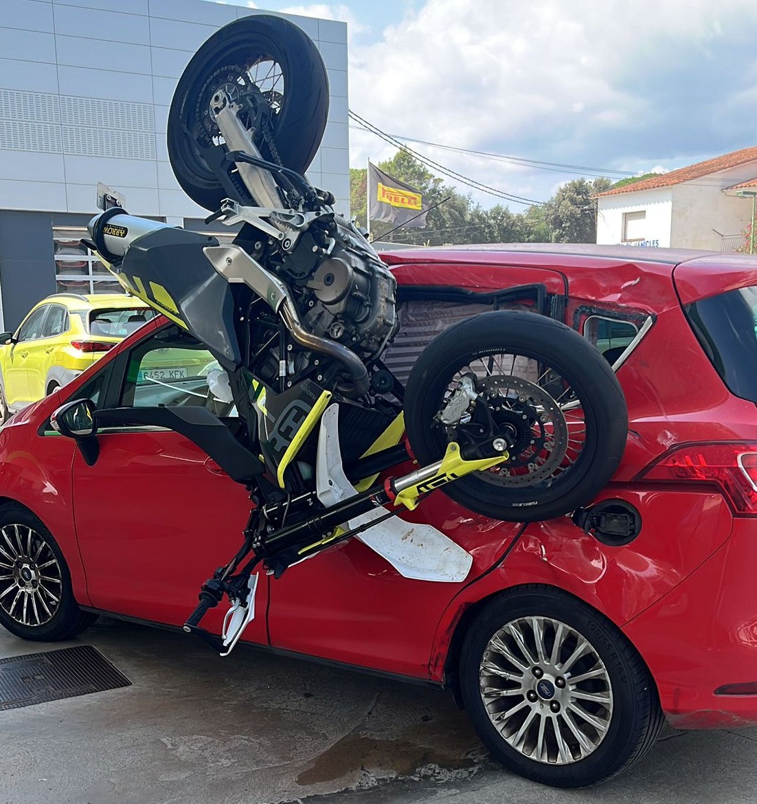 La moto enganxada al cotxe després del xoc