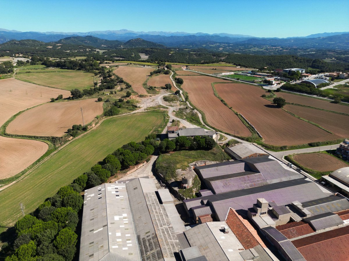 Vista aèria de la confluència entre els termes municipals de Lluçà i Prats, amb la zona esportiva o les naus de l'empresa Obradors