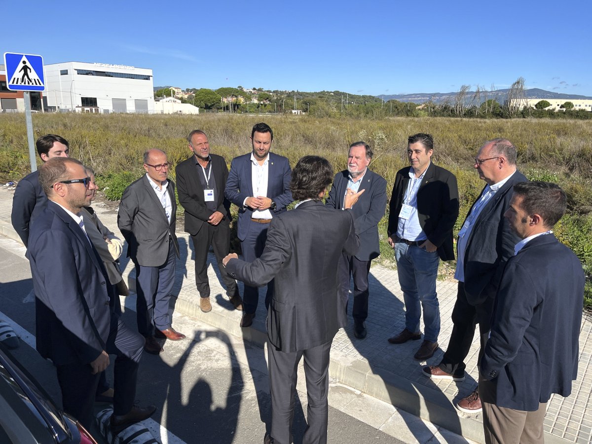 Un directiu de Grifols explica detalls del projecte a la delegació institucional, als terrenys on s’edificarà la planta