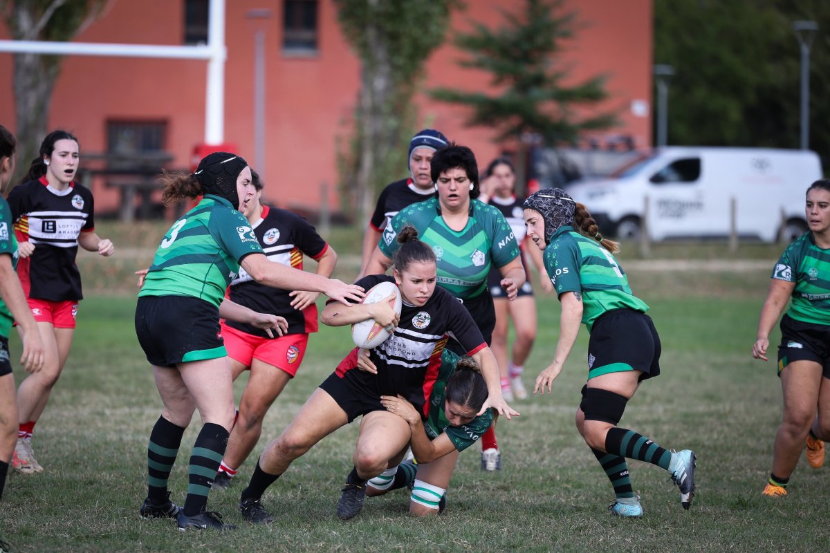 Una jugadora del CAT Central intenta endur-se la pilota entre les rivals, dissabte al partit disputat a Vic