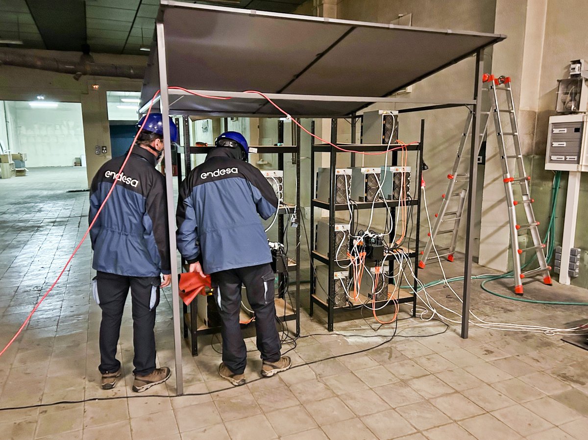 Tècnics d'Endesa mirant els ordinadors que funcionaven a tot drop en una de les naus de Manlleu