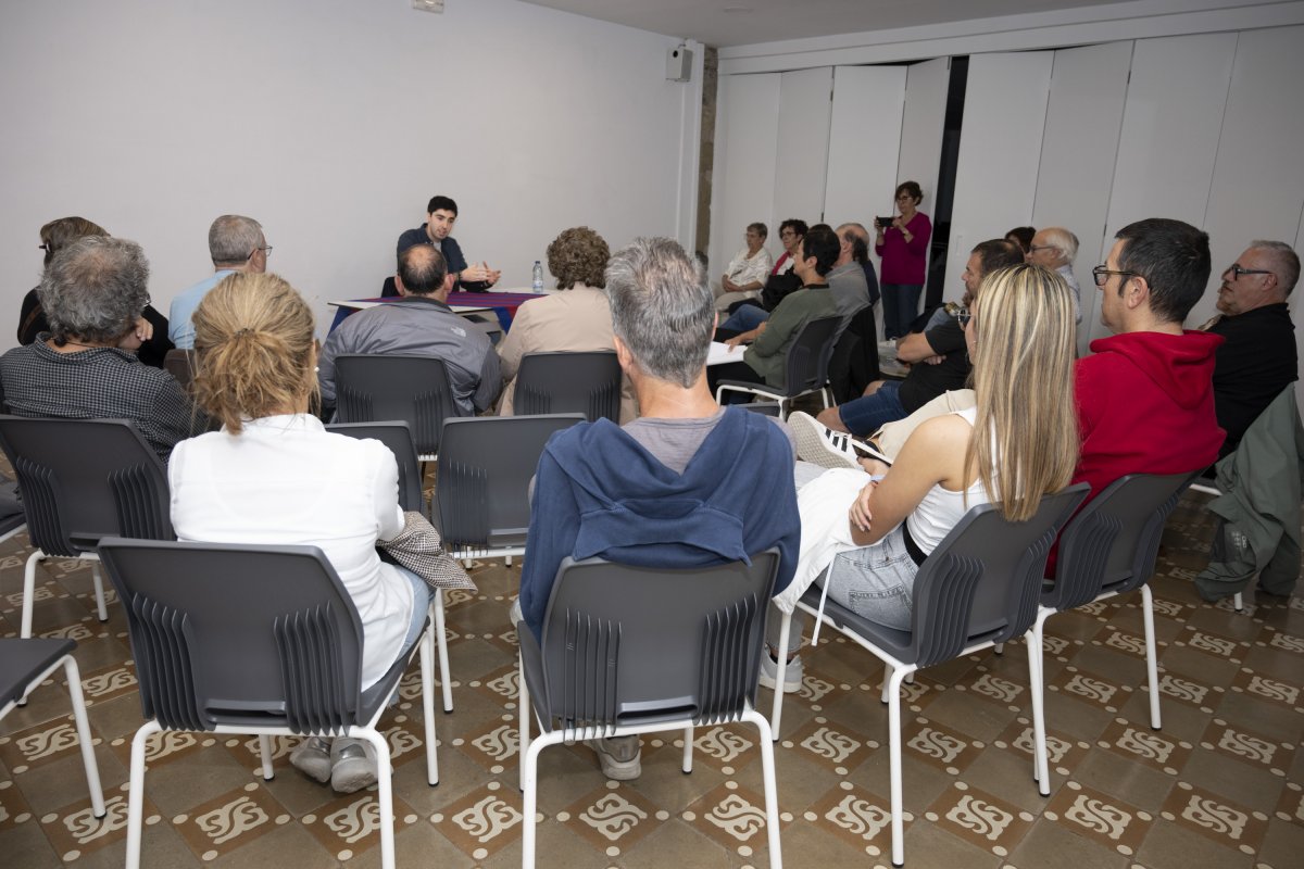 El periodista Pol Ballús i el públic assistent a la xerrada