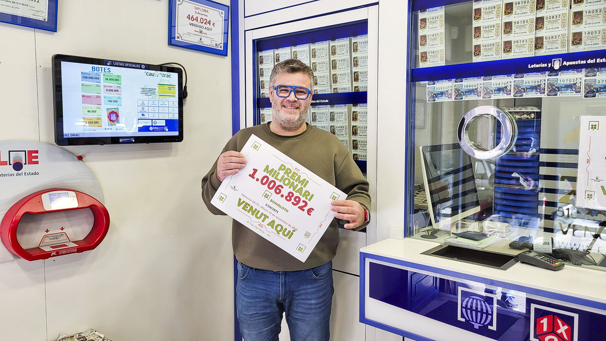 El propietari de l’establiment, Miquel Colina, amb el cartell del premi