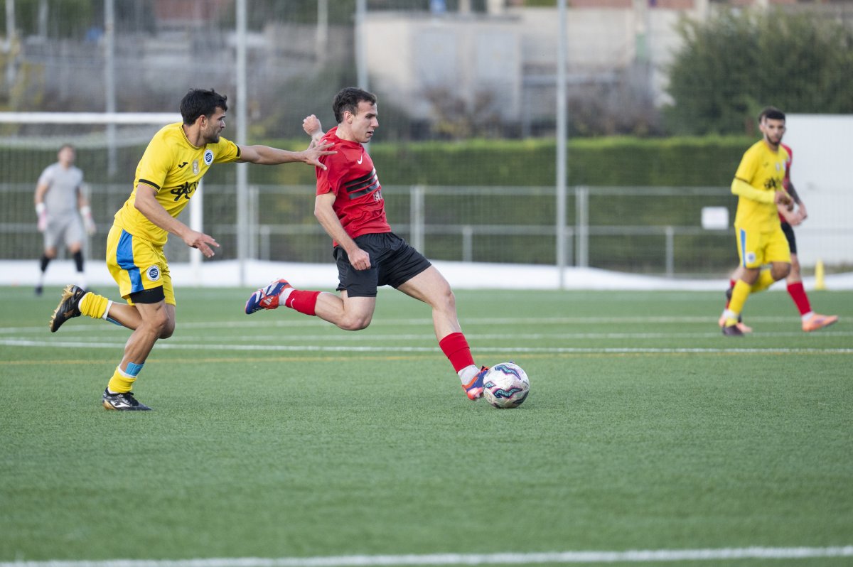 Marc Llobet intenta un xut davant la pressió d'un rival