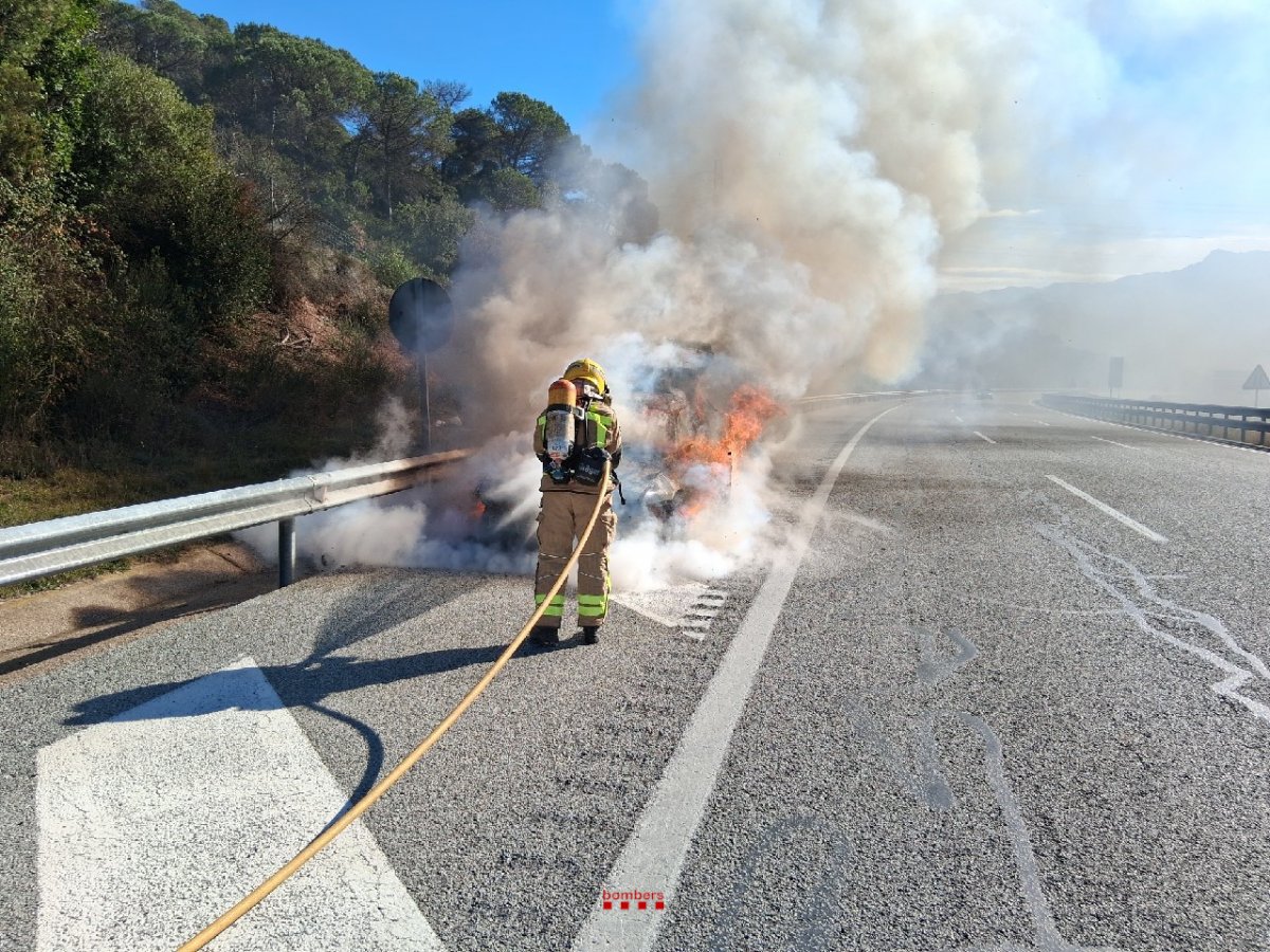 Els Bombers, apagant el cotxe incendiat