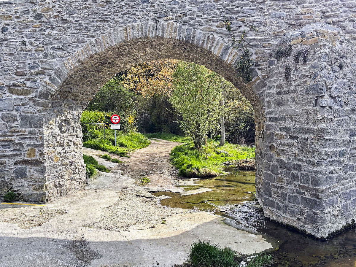 El pont romànic del carrer del Pont. A sota, un dels senyals sobre l’accés